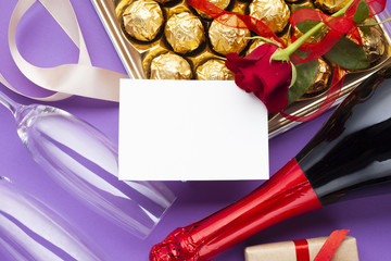 Flat lay decoration with chocolate box and wine bottle