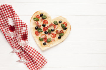 Top view heart shaped pizza on table with cloth