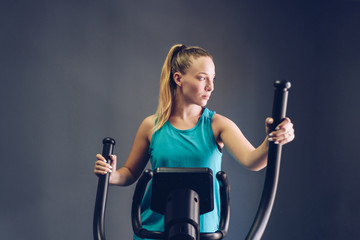 Woman Exercise Elliptical cardio running workout at fitness gym - obrazy, fototapety, plakaty