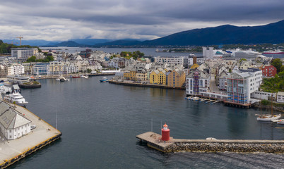 Fototapeta na wymiar Alesund, Norway - July, 2019: Pier leading to the red lighthouse. Aerial view from above(drone shot)