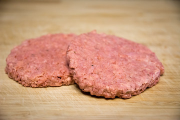 Two vegan and plant based burgers on a wooden plate