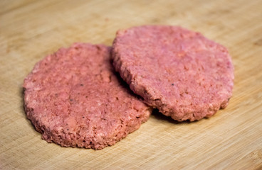 Two vegan and plant based burgers on a wooden plate