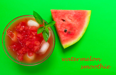 Watermelon smoothies with ice in a glass and mint leaves on a bright green background. Top view. Close-up.