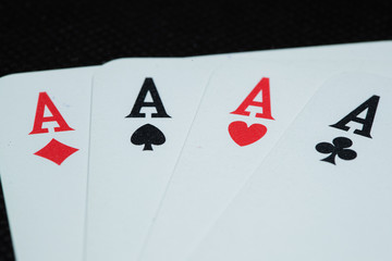 Cards laid four aces hearts diamonds space cross side by side closeup macro view of cards on black background.