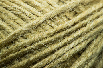 Close-up macro view of twine or string from natural fabric wrapped in a ball.