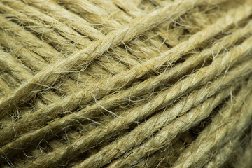 Close-up macro view of twine or string from natural fabric wrapped in a ball.