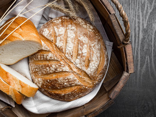 freshly baked bread in basket on dark gray kitchen table, top view,copy space