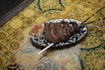 Fried meat on skewers with onions and paprika