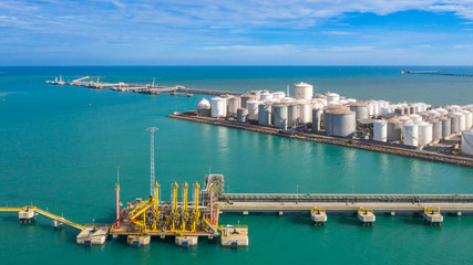 Aerial view loading arm oil and gas refinery at commercial port, Tank terminal with lots of oil storage tank and petrochemical storage tank in the port, Industrial tank storage aerial view.