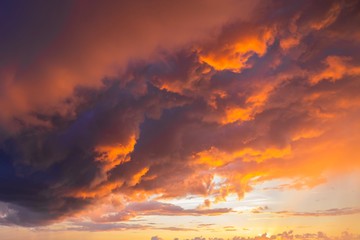 Dramatic sunset through a cloudy dark sky over the ocean.
