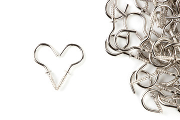 Metal rest cup Curtain Hooks or for hanging various accessories with one side are hooks. And the other side is a pointed screw. It splice a symbol resembling a heart isolated on white background.