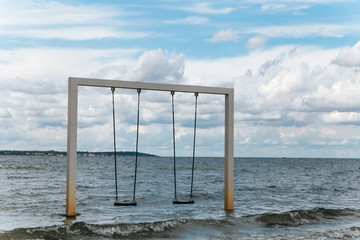 Couple swing on beautiful sea shore and beach, Sweden, Helsingborg
