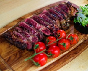 Serving freshly cooked beef steak on a wooden board