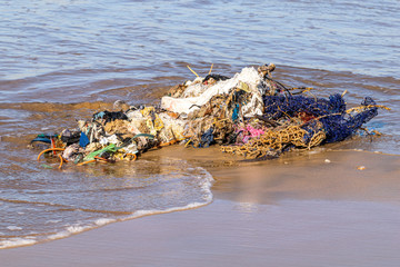 Fishing nets and pollution rubbish washed up from the Atlantic Ocean onto a sand beach in Agadir,...