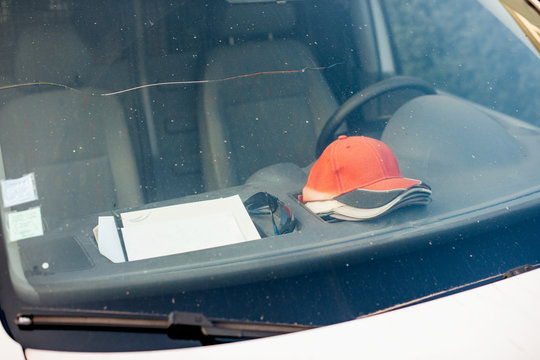 Construction Van Parked On Street With Multiple Working Baseball Hats Cap On The Dashboard