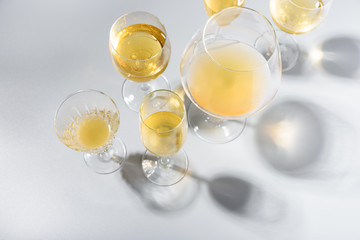 Wineglasses of white wine with shadows on gray background. Top view. Holiday celebration concept