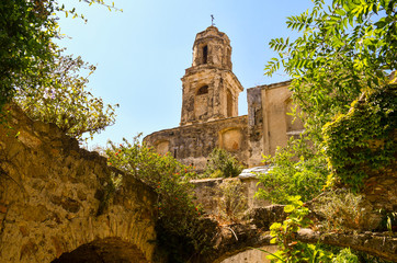 Fototapeta na wymiar View of the ruins of the Church of Sant'Egidio, whose bell tower has miraculously escaped the earthquake of 1878 that caused the abandonment of the medieval village, Bussana Vecchia, Imperia, Italy