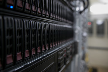 Computer Server mount on rack in data center room with red lighting alarm.