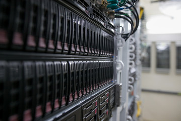 Computer Server mount on rack in data center room with red lighting alarm.