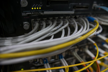 Server rack with red internet patch cord cables connected to patch panel in server room