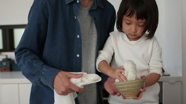 Father and daughter cleaning bowls