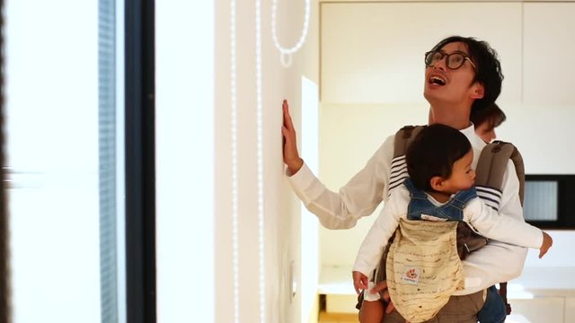 Father carrying baby son in baby carrier