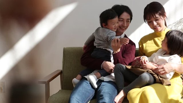 Parents playing with children on sofa