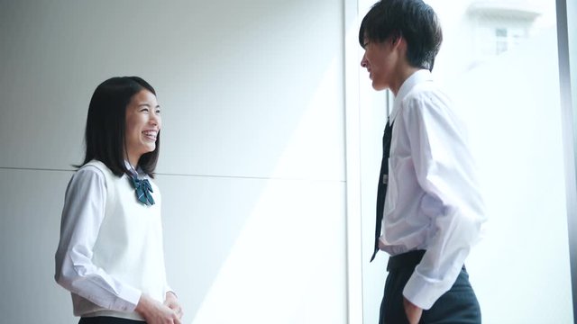 Two high school students standing and talking