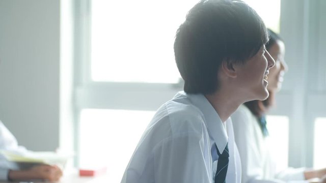 Smiling high school boy listening in classroom