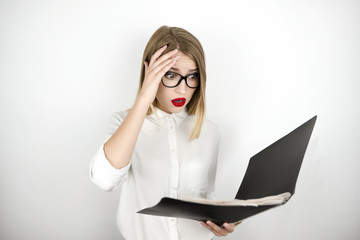 young beautiful business woman in eyeglasses looks confused holding black folder with documents isolated white background