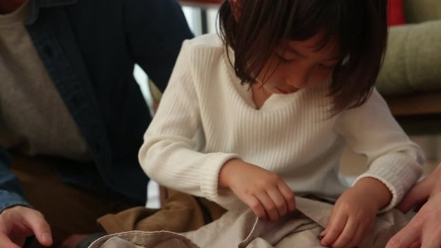 Little girl buttoning shirt