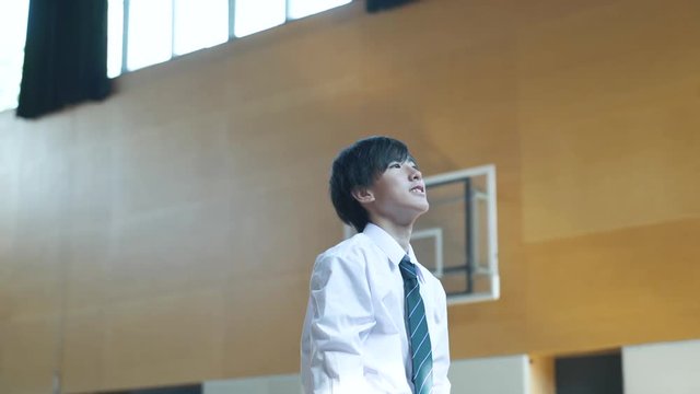 High school boy playing basketball in gymnasium
