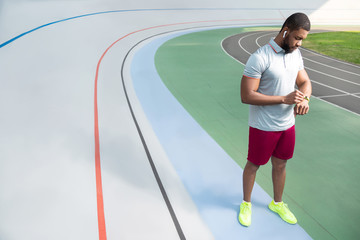 Obraz premium African American sportive man checking his fitness tracker