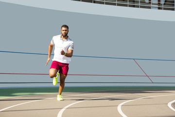 Fototapeta premium Aktywny młody sportowiec na bieżni