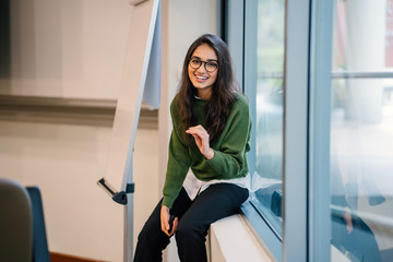 Portrait of a young, educated, confident and intelligent-looking Indian Asian teacher woman smiling...