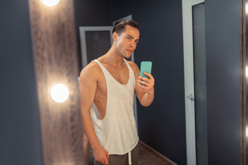 Nice attractive man taking a selfie in the mirror