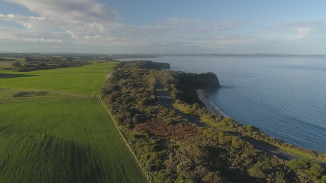 4k aerial footage along winding coastal road and countryside.