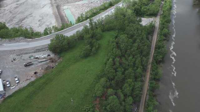 Drone flies back to reveal a quarry and a river in the Midwest USA.  in summer, in 4K.