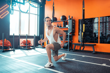 Pleasant fit man trying to train his muscles