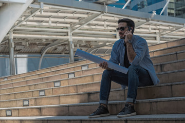  Young engineer sitting and using smartphone