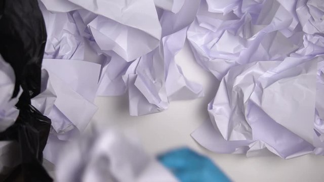 Janitor in gloves collecting paper in office, inefficient material usage, damage