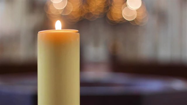 Yellow candle burning in the magdeburg cathedral with a blury background