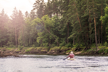 Back view kayaker on summer green forest river landscape with blue sky