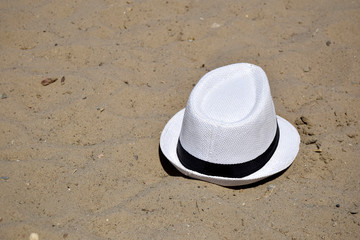 Fototapeta na wymiar The hat men's white is on sand. Summer, beach.