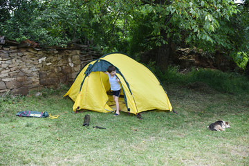 Child making tent for camping outside. Boy have fun with a tent