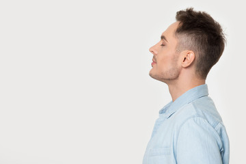 Profile view man standing aside on grey studio background