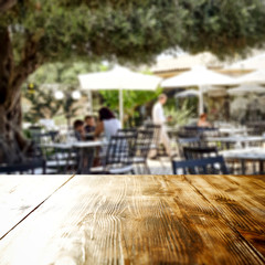 Wooden table top background  in an outdoor restaurant view. Empty  space for your decoration and an advertising product.