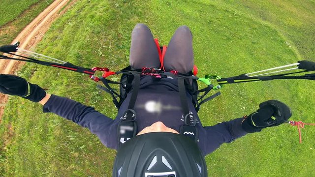 Woman is managing the paraglider while flying