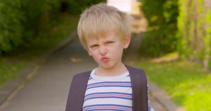 Portrait of a cute little boy scrunching his nose and acting grumpy
