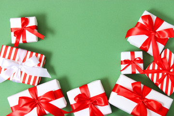 Set of beautifully wrapped gift boxes on a colored background top view. Christmas gifts,...